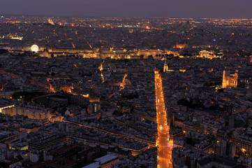 Aerial view of Paris by night. Louvre, Saint Michel, and many other landmarks are visible.