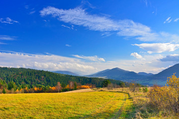 Dirt road and autumn mountains landscape in sunny day, Low Beskids (Beskid Niski).