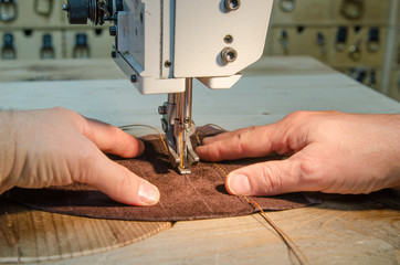 Man working with leather using leather sewing machine  - obrazy, fototapety, plakaty
