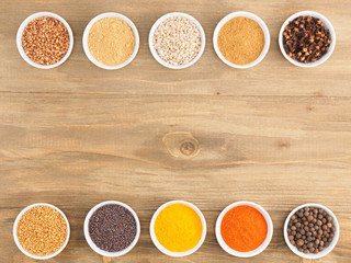 Buckwheat, oat, allspice, dry ginger, pepper chili, fenugreek, turmeric, cloves, masala, mustard seeds on brown wooden background with copy space. Indian cuisine, ayurveda, naturopathy concept