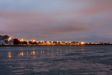 Distant lights with starburst effects along Sandymount Strand, Dublin, Ireland. Fading light, twilight, low tide, tide out, Sandymount beach