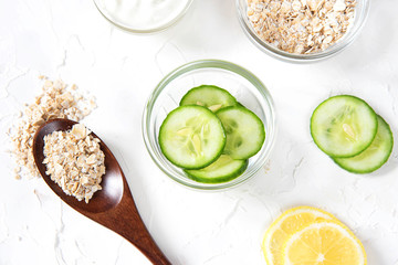 Homemade cosmetics with cucumber and yogurt and oatmeal on a white background. Ingredients for the mask