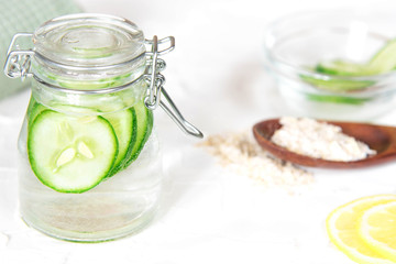 Bottle with cucumber water on white background. Fresh skin care tonic