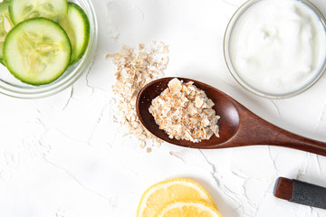 Homemade cosmetics with cucumber and yogurt and oatmeal on a white background. Ingredients for the mask