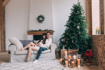Photo shoot in the studio of a young married couple. Photographing of pregnancy. A guy with a girl is celebrating Christmas. New Year's love story.
