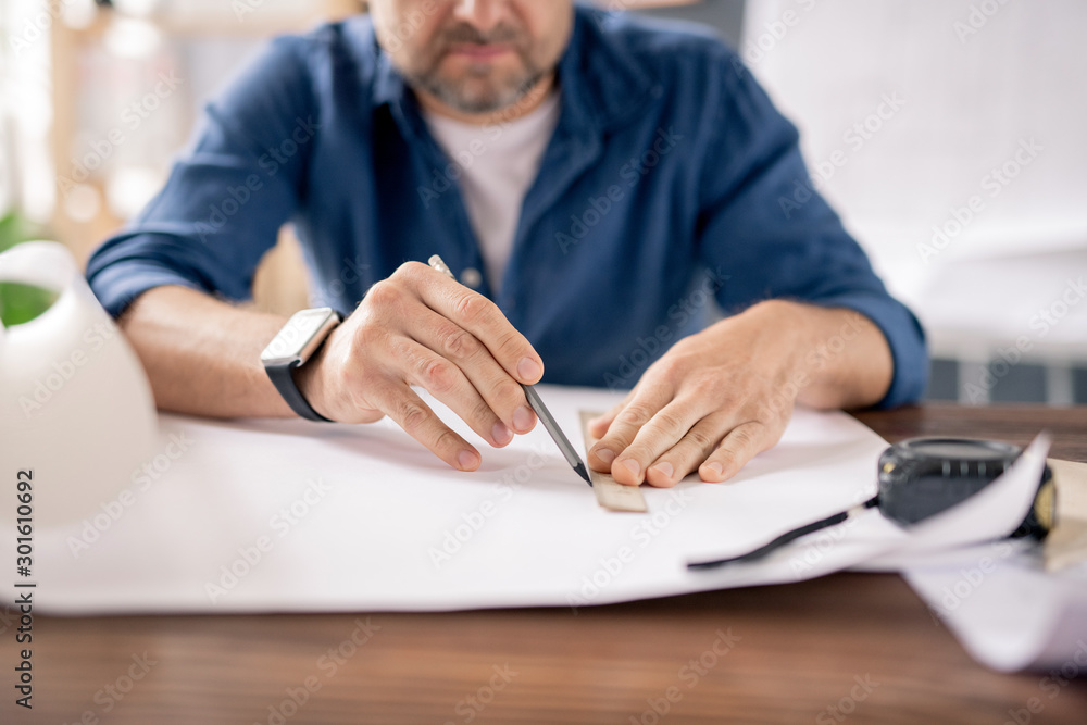 Poster Hands of modern engineer with pencil and ruler drawing line on blueprint