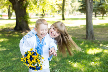 mother and son in embroidered shirts. national clothes of Ukraine. a boy gives flowers to his mother