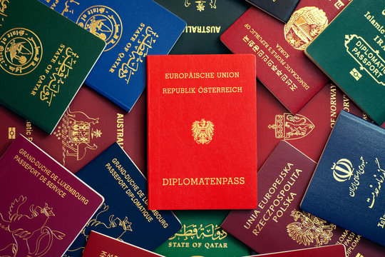 Austrian diplomatic passport on the background of multi-colored passports of the world