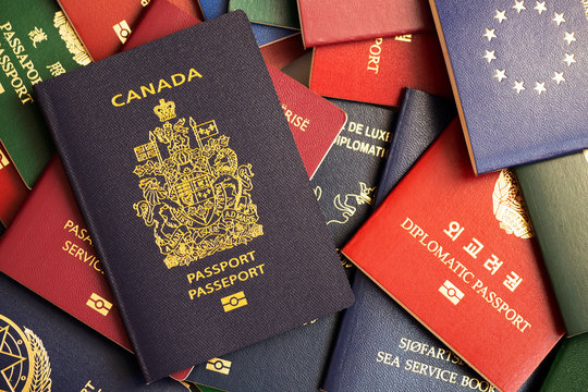 Canada biometric passport on the background of multi-colored passports of the world.