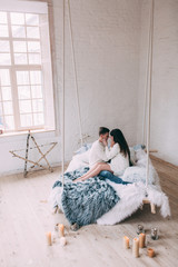 Photo shoot in the studio of a young married couple. Photographing of pregnancy. 