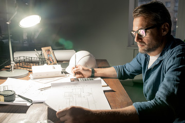 Serious engineer decided to stay at work for night to check sketches