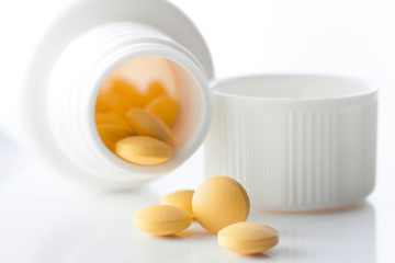 yellow pills spilled out of medicine box