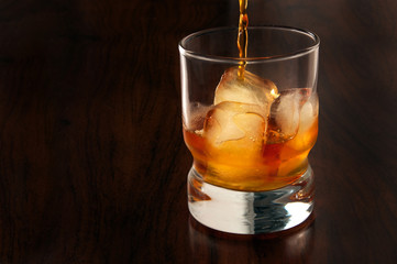 glass of whiskey and ice on black background
