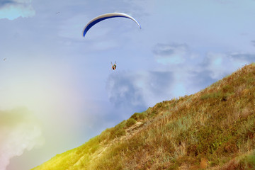 A man flies a paraglider in the beautiful nature. Clear skyline between earth and sky. Place for...