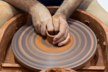 hands that shape the clay pottery Turning
