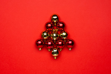 Red and gold Christmas decoration balls on red background. Winter season minimal composition