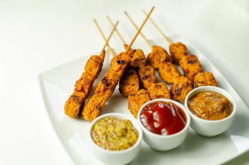Satay chicken breast marinated in Indonesian style spices and grill on wooden skewers with dip peanut, ketchup, mustard
