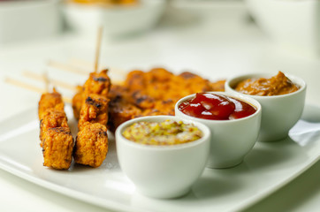 Satay chicken breast marinated in Indonesian style spices and grill on wooden skewers with dip peanut, ketchup, mustard