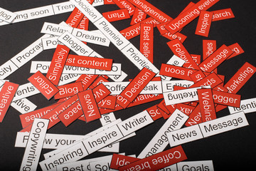 Word cloud of business themes cut out of red and white paper on a gray background