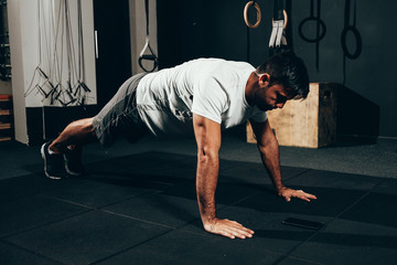 Fototapeta premium Strong man doing pushups at the gym. Calisthenics, bodyweight training