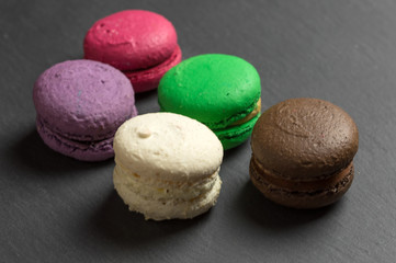 Sweet and colourful french macaroons or macarons on a dark slate plate