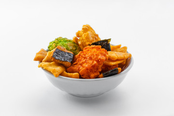 Japanese snacks with seaweed and wasabi lie in a white bowl on a white background
