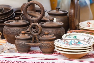traditional style modern handmade ceramic clay decorative twin crocks (double pots) with a handle and cover lids, carved abstract, floral patterns, outdoor ethno festival fair sale, kitchen utensils