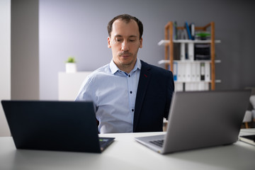 Businessman Doing Multitasking Work In Office