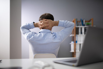 Relaxed Businessman Sitting In Office