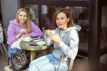 Positive delighted girls looking straight at camera