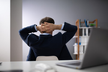 Relaxed Businessman Sitting In Office
