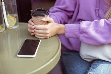 Close up of female hands that embracing paper cup