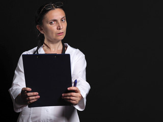Female doctor shows emotion posing on black background. Female doctor in white coat shows different emotions posing on black background. Doctor template. 