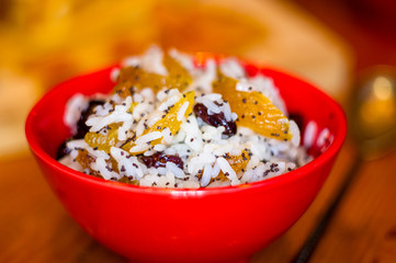 handmade preparation of treats for traditional Orthodox Christmas - rice pudding with fruits, cranberries, honey, nuts, Church candles