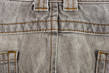 clothing items stonewashed cotton fabric texture with seams, clasps, buttons and rivets, macro