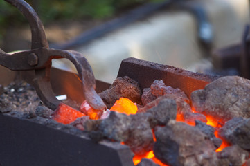 Fototapeta na wymiar blacksmith furnace with burning coals, tools, and glowing hot metal workpieces