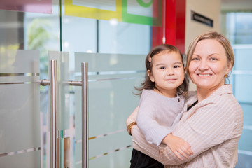 Happy mother accompanies her daughter to school