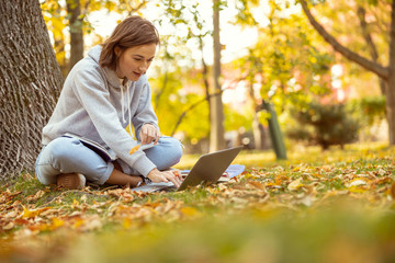 Positive delighted young woman working at computer