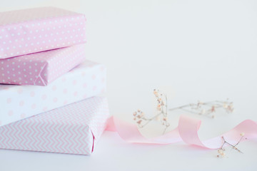 packaging gifts in pink paper, pink ribbon, little white flowers