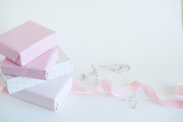 packaging gifts in pink paper, pink ribbon, little white flowers
