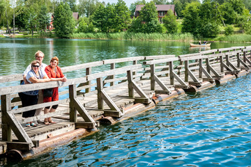 A group of Mature people walk on a pontoon bridge