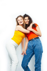 young pretty teenage girls friends with blond and brunette curly hairs posing cheerful isolated on white background, lifestyle people concept