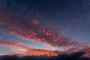A dramatic sunset or sunrise sky with clouds. Orange and purple colors on a dramatic looking sky.