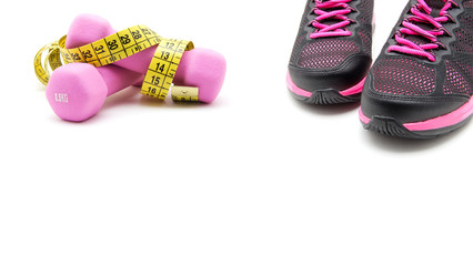 Sport shoes and two of pink dumbbells isolated on white background