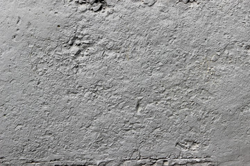 Texture of a wall made of concrete and crushed stone and painted with gray paint