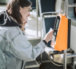 A young woman contactless pays for public transport.