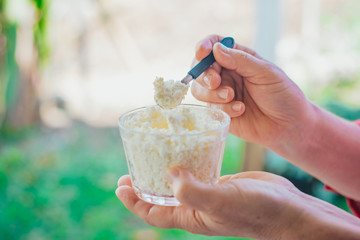 hand on spoon eating homemade grainy curd