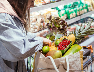 A young woman buys groceries in a supermarket.
