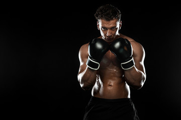 Fototapeta na wymiar Boxer, man fighting or posing in gloves on black background. Fitness and boxing concept. Individual sports recreation.