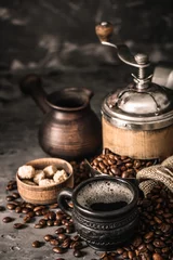 Foto op Aluminium Coffee cup with coffee grinder and coffee beans on dark textured background. © zadorozhna